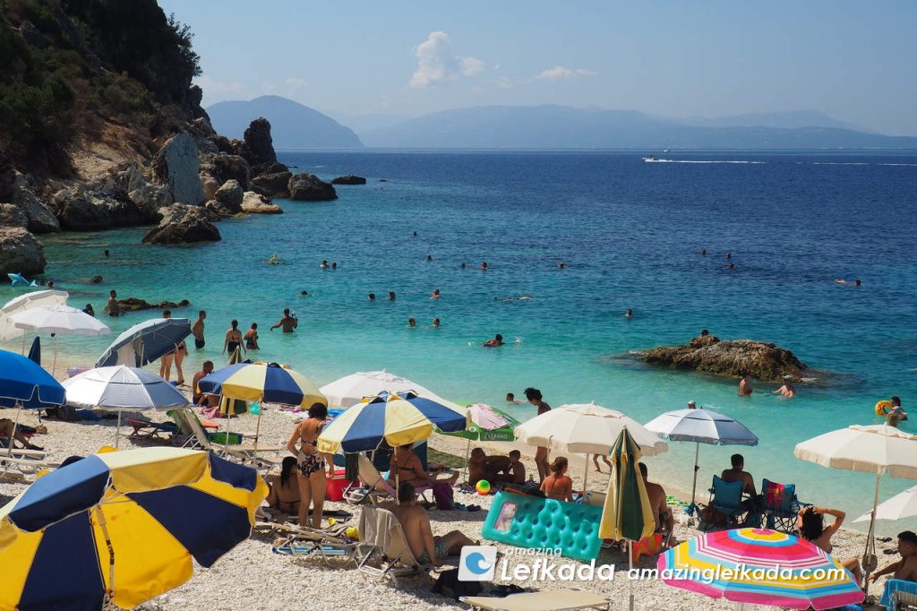 Blue sea, sunbeds and white pebbles of Ionian Sea at Paralia Agiofili