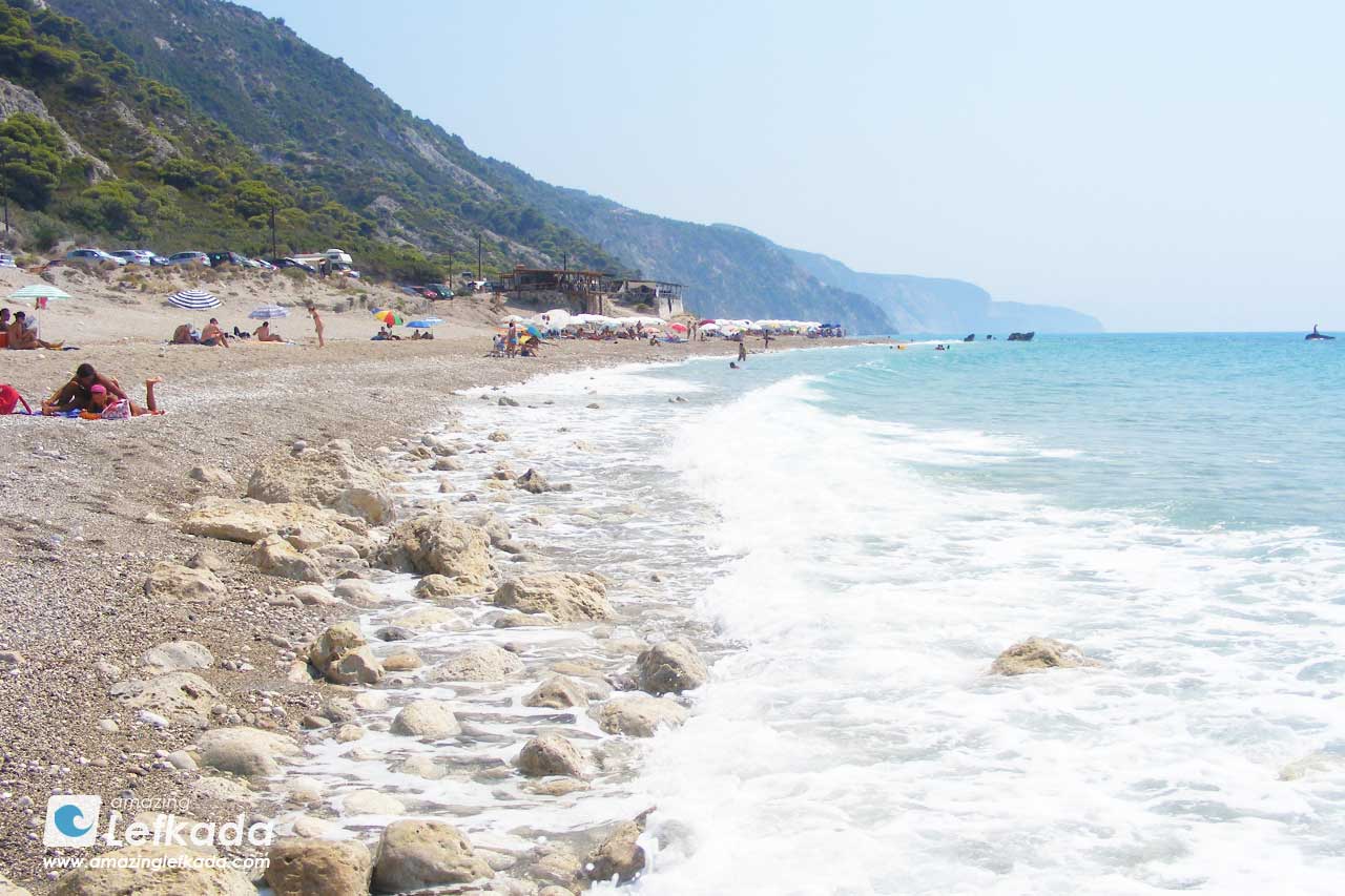 Gialos beach with sunbeds and restaurants, parking lot