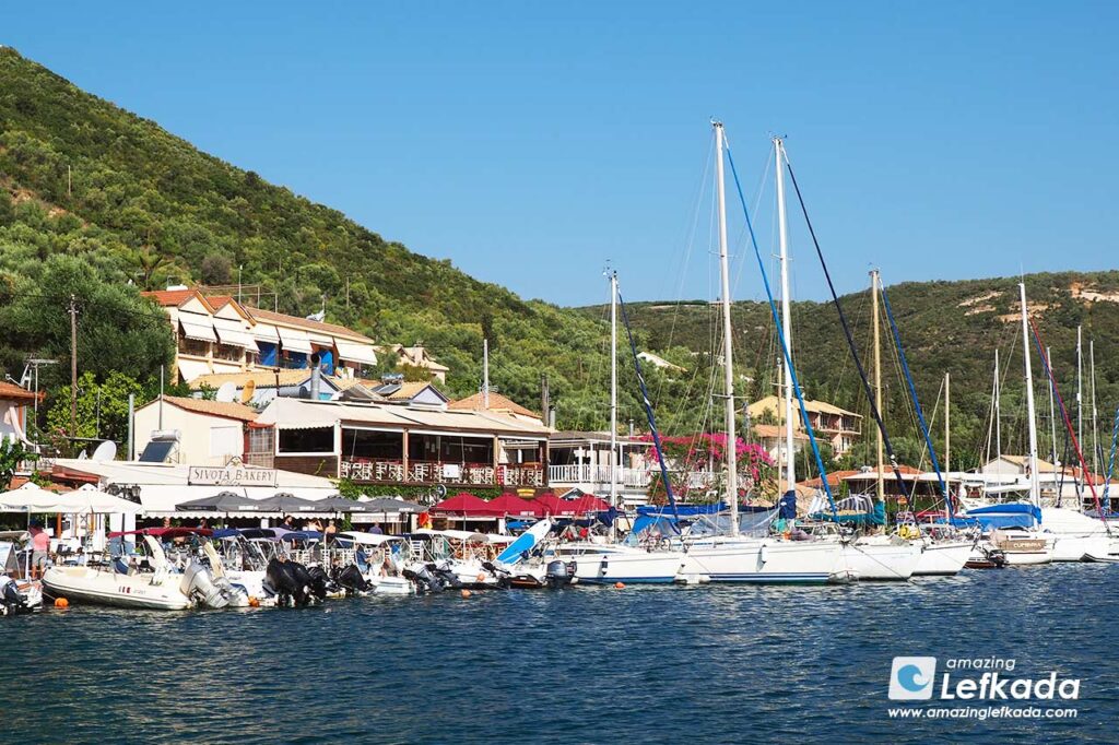 Houses of Sivota village with boats in a port